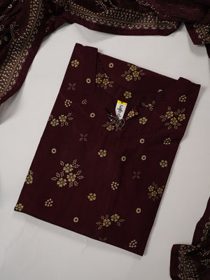A folded dark maroon fabric piece with small gold floral and dot patterns, shown on a white surface with matching draped fabric partially visible at the edges.